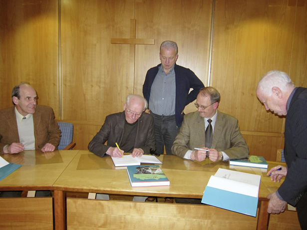 Die Autoren signieren den zweiten Band der Wendener Gemeindegeschichte